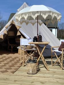 una mesa y sillas frente a una tienda en Luxury Tent with Restroom and shower, close to the Beach, en Ystad