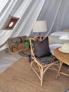 1 dormitorio con tienda de campaña con silla y mesa en Luxury Tent with Restroom and shower, close to the Beach, en Ystad
