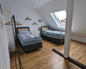 Duas camas num pequeno quarto com uma janela em Rheinische Gemütlichkeit, Sali Homes Zentrales Heim in Kleve em Kleve
