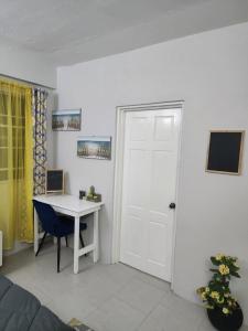 Zimmer mit einem Schreibtisch, einer Tür und einem Tisch in der Unterkunft Sunsetcrest Tranquil Getaway in Castries