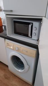 un microondas sobre una lavadora en Apartamento parque sur de Hellín, en Hellín
