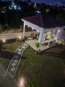 a gazebo with a bench in a yard at night at Sunsetcrest Tranquil Getaway in Castries