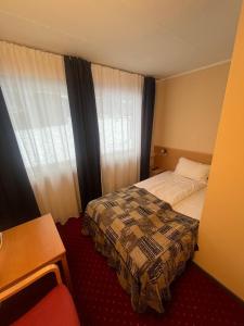 a hotel room with a bed and a window at Welcome Inn Hotel Lyngskroa in Oteren