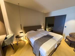a hotel room with a bed and a chair at Hotel Villa Select in De Panne