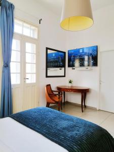 a bedroom with a bed and a table and a window at Eden Hotel in Haifa