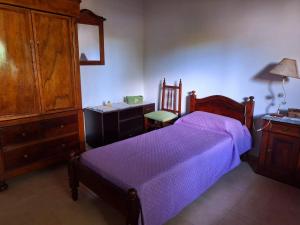 1 dormitorio con 1 cama, vestidor y silla en Cabaña La Encarnación en La Paz
