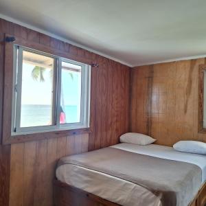 a small room with two beds and a window at Casa Rural El Paraíso de Saona in Mano Juan
