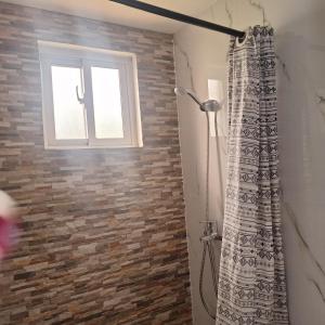 a bathroom with a shower curtain and a window at Casa Rural El Paraíso de Saona in Mano Juan