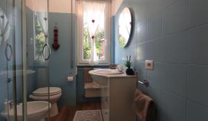 uma casa de banho com um lavatório, um WC e uma janela. em Como Petite Maison em Como