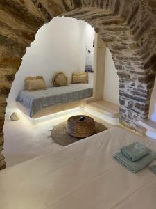a room with a bed with a stone wall at Cave Dame in Mési