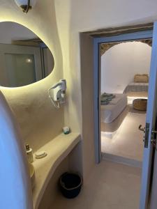 a bathroom with a mirror and a bed in a room at Cave Dame in Mési