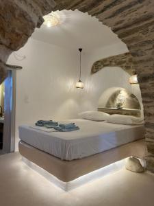 a bedroom with a bed in a stone wall at Cave Dame in Mési