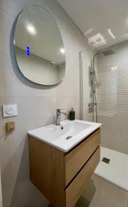 La salle de bains est pourvue d'un lavabo et d'un miroir. dans l'établissement Appartement Balaruc les bains, à Balaruc-les-Bains