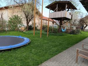 einen Spielplatz mit Trampolin und ein Baumhaus in der Unterkunft Ferienwohnung auf dem Land in Tuntenhausen