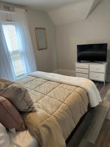 um quarto com uma cama e uma televisão de ecrã plano em Lakeside Haven Oasis (Upper) em Racine