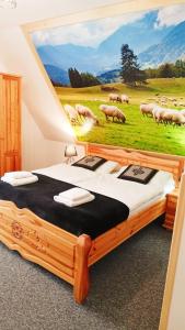 een slaapkamer met een bed met een schilderij van schapen bij Willa na górskim szlaku in Ciche Małe