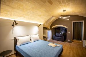 een slaapkamer met een blauw bed en een stoel bij Casa Nera GuestHouse in Montescaglioso