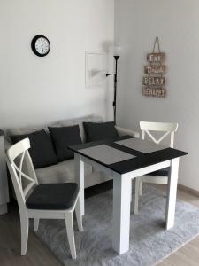 a table and two chairs and a couch in a living room at FeWo Im Grünen in Lilienthal +3 photos