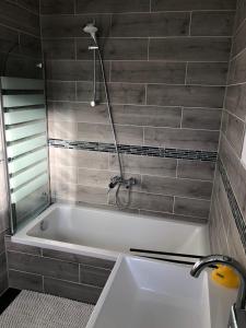 La salle de bains est pourvue d'une baignoire et d'une douche. dans l'établissement FeWo Im Grünen, à Lilienthal