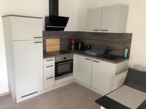 a kitchen with white cabinets and a sink at FeWo Im Grünen in Lilienthal