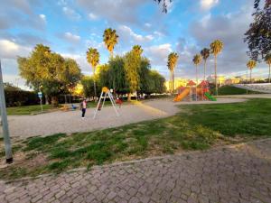 a playground with a slide in a park with palm trees at La casa antica in Modugno