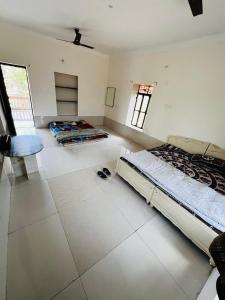 Un dormitorio con 2 camas y una silla. en CHK Emerald Villa’s Pushkar en Pushkar