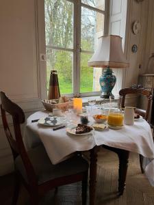 una mesa con platos de comida y bebidas. en Château de Contay Guesthouse - 1753, en Contay