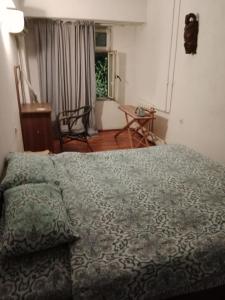 a bedroom with a bed and a table and a window at Apartment Tsentr 5 in Tashkent