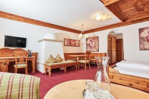 Habitación con cama y mesa con jarrón en All In Resort Schwarzbrunn - 4 Sterne Superior, en Stans