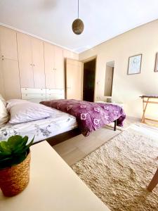 ein Schlafzimmer mit einem Bett und einem Teppich in der Unterkunft Xrysa's Garden in Mesolongi