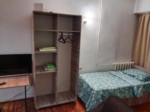 Habitación pequeña con cama y estante para libros en Apartment Tsentr 5, en Tashkent