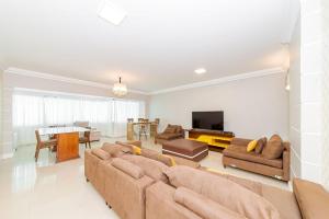 uma sala de estar com um sofá e uma televisão em Apto Amplo 1SUI+2Q Quadra Mar 50m da Praia em Balneário Camboriú