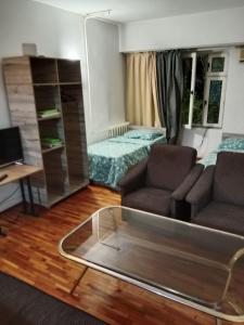ein Wohnzimmer mit einem Sofa, einem Bett und einem Schreibtisch in der Unterkunft Apartment Tsentr 5 in Taschkent