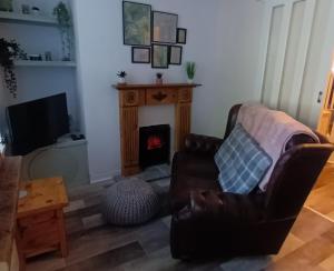 a living room with a couch and a fireplace at Cosy Mews House Close to Harbour in Porthmadog