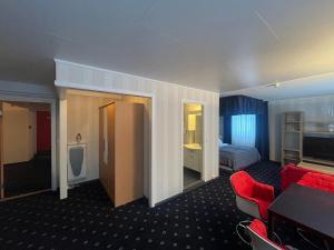 a hotel room with a red couch and a bed at Welcome Inn Hotel Lyngskroa in Oteren