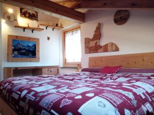 a bedroom with a bed with a red and white blanket at L'angolo di Emma in Varena