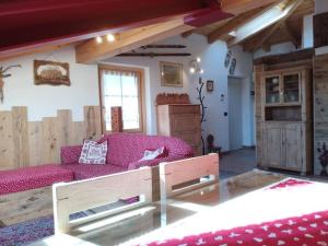 a living room with a purple couch and a window at L'angolo di Emma in Varena