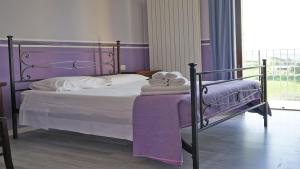 een slaapkamer met een bed met paarse lakens en handdoeken bij Il Castellano Vacanze in Porto SantʼElpidio