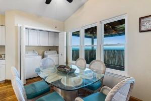 a dining room with a glass table and chairs at Bay Haven on Copano- 4 bdrm w/ 200+ft Fishing Pier in Rockport
