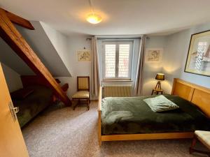 Schlafzimmer mit einem Bett und einem Fenster in der Unterkunft Au jardin de la Maison des Soeurs in Mutzig