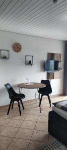 - une salle à manger avec une table et deux chaises dans l'établissement Gästehaus Fechtig, à Hergensweiler
