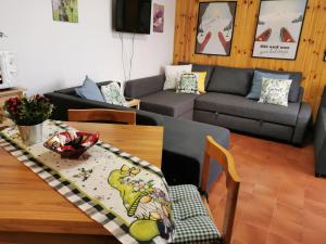a living room with a table and a couch at La Casetta degli Gnomi in Faidello