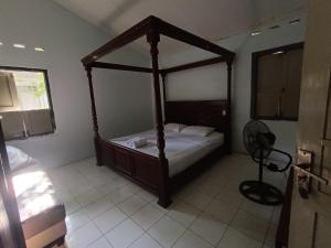 ein Schlafzimmer mit einem Himmelbett in einem Zimmer in der Unterkunft Ndalem Mantrigawen in Yogyakarta
