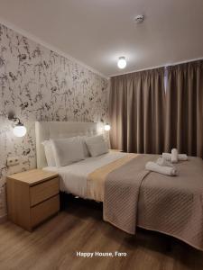 法魯的住宿－幸福旅館，一间卧室设有两张床和华丽的壁纸