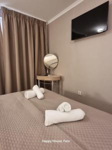 Un dormitorio con una cama con dos toallas encima. en Happy House, en Faro