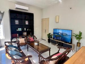a living room with a table and a tv at Garden Homestay Kuala Terengganu in Kuala Terengganu