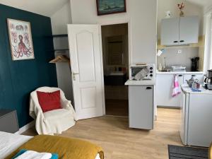 a small kitchen with a white refrigerator and a chair at Penty de Mézareun in Ouessant