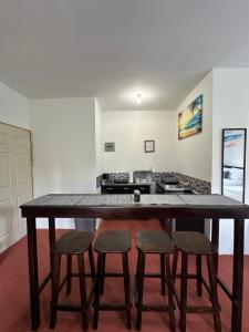 a large wooden table with four chairs in a kitchen at Keona Beach in La Libertad
