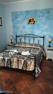 a bedroom with a large bed with a black frame at Bed and Breakfast Don Angelo Miramare in Realmonte