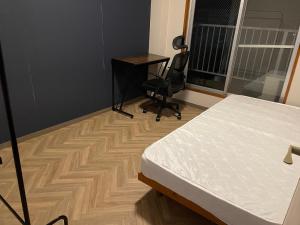 een slaapkamer met een bed, een bureau en een stoel bij 貸別荘 Reserved VacationStay UND Oita Saiki in Saiki